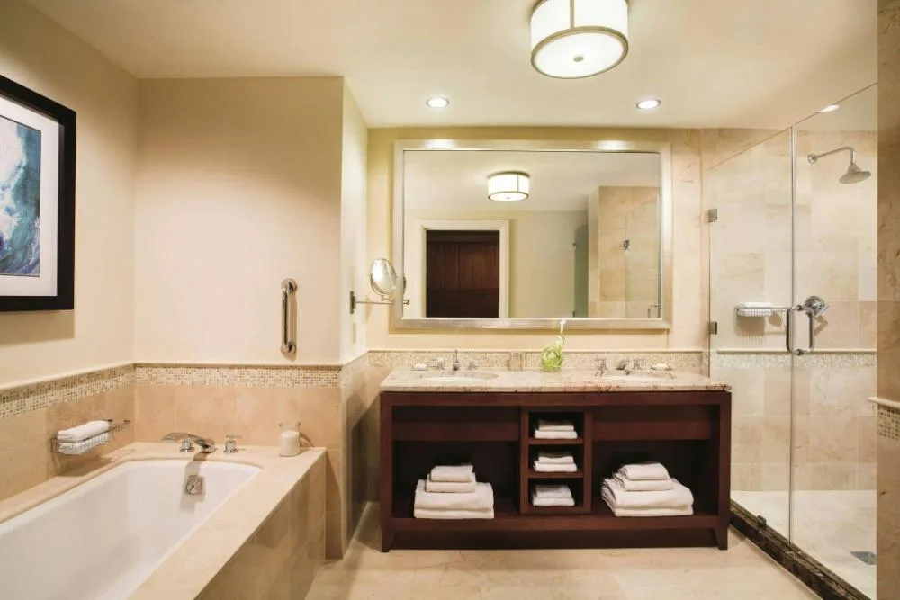 Junior Suite bathroom with tub, double vanity, and glass shower at The Ritz-Carlton, Aruba.