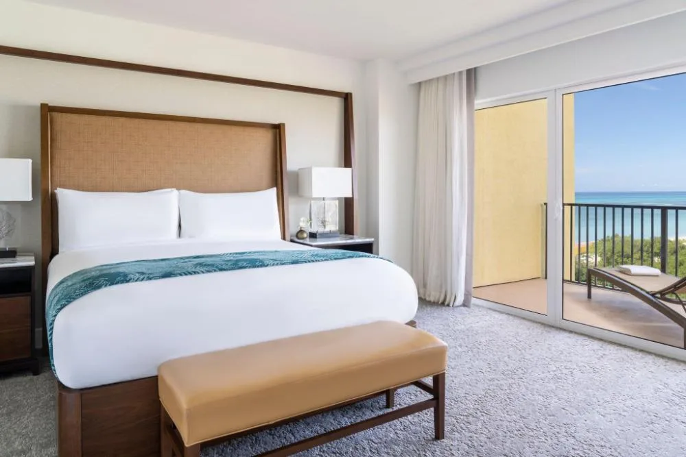 Junior Suite bedroom with king bed and ocean-view balcony at The Ritz-Carlton, Aruba.