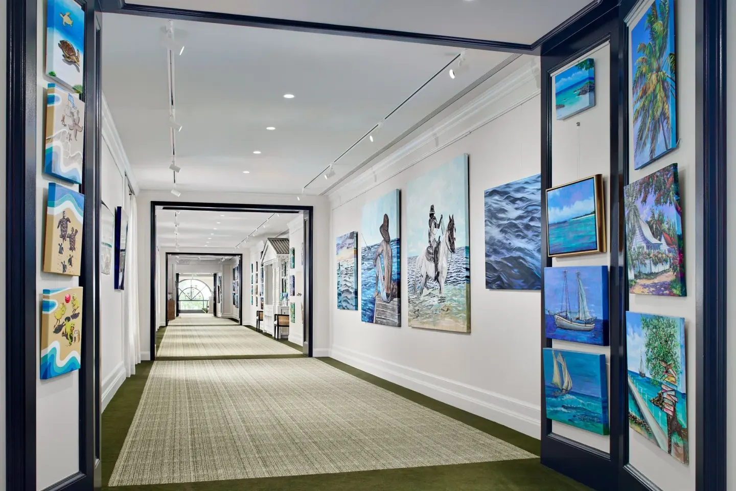 Art-lined corridor with colorful island paintings at The Ritz-Carlton, Grand Cayman.