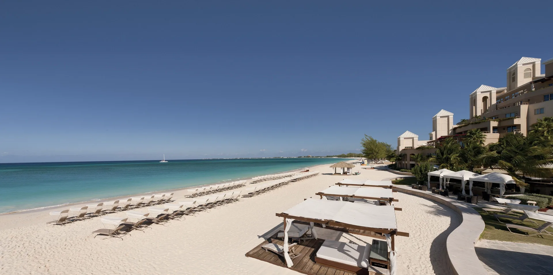 Beachfront loungers and cabanas along the shore at The Ritz-Carlton, Grand Cayman.