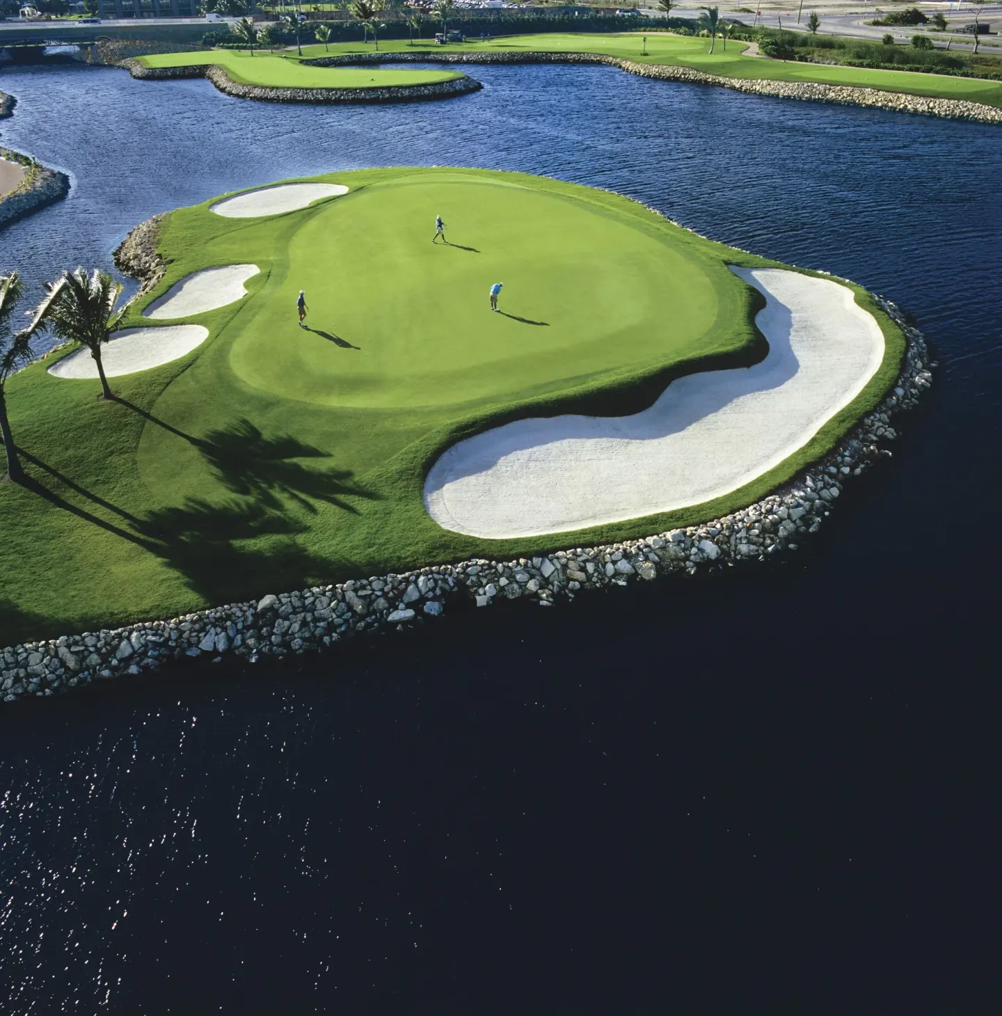 Golf green with sand bunkers surrounded by water at The Ritz-Carlton, Grand Cayman.