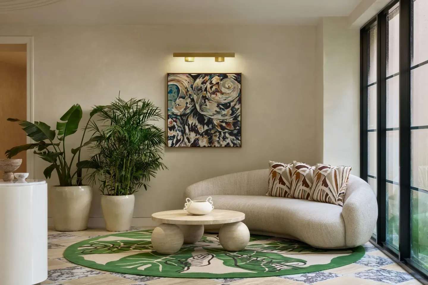 Curved sofa, plants and abstract art in a lounge nook at The Ritz-Carlton, Grand Cayman.