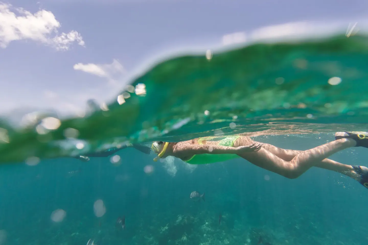 A snorkeler swims through clear turquoise water at The Ritz-Carlton, Grand Cayman.