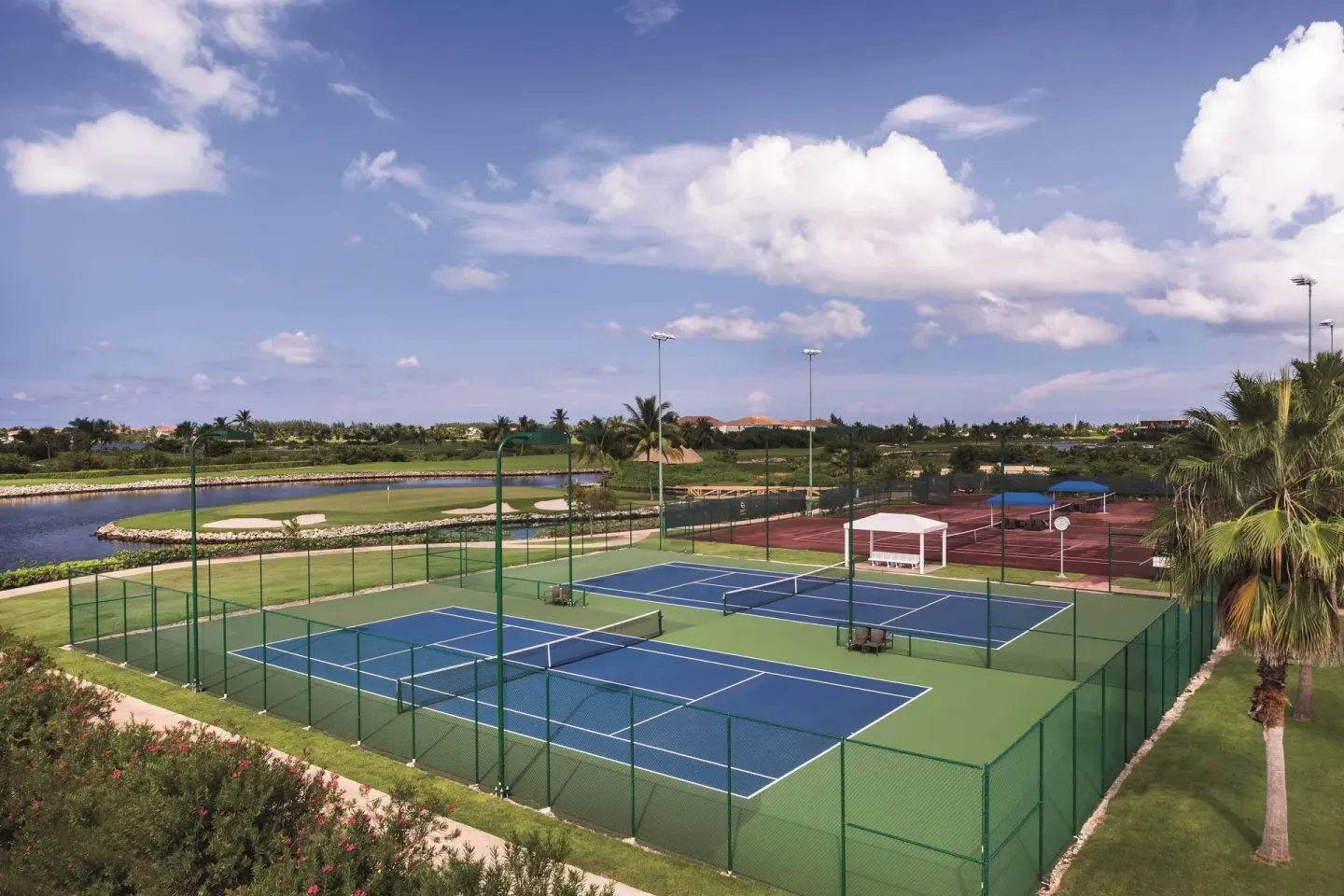 Fenced tennis courts and surrounding resort grounds at The Ritz-Carlton, Grand Cayman.