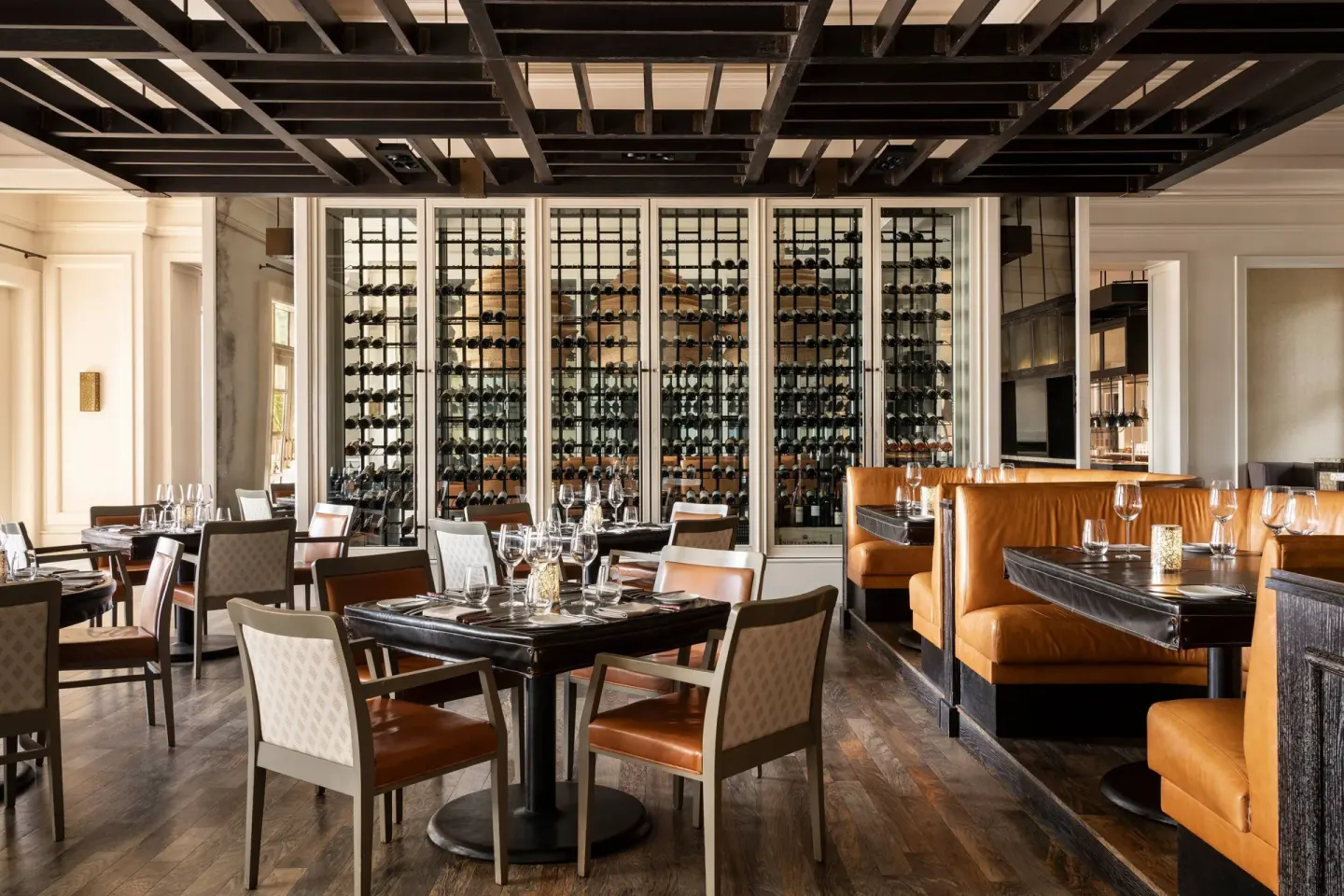 A restaurant dining room with booths and wine display at The Ritz-Carlton, Grand Cayman.
