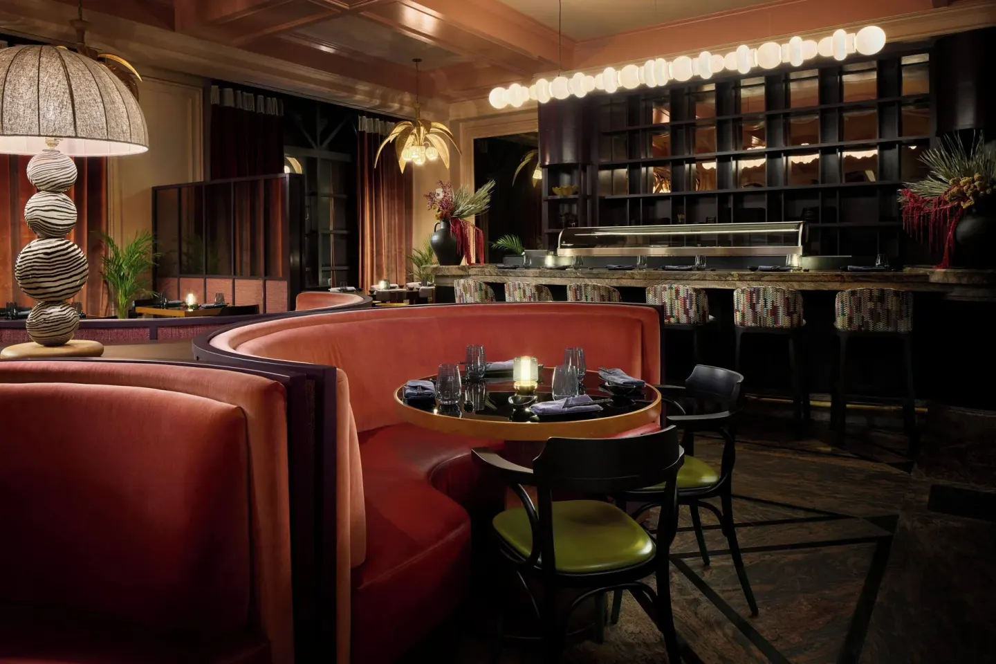 A dim sushi bar dining room with curved booths at The Ritz-Carlton, Grand Cayman.