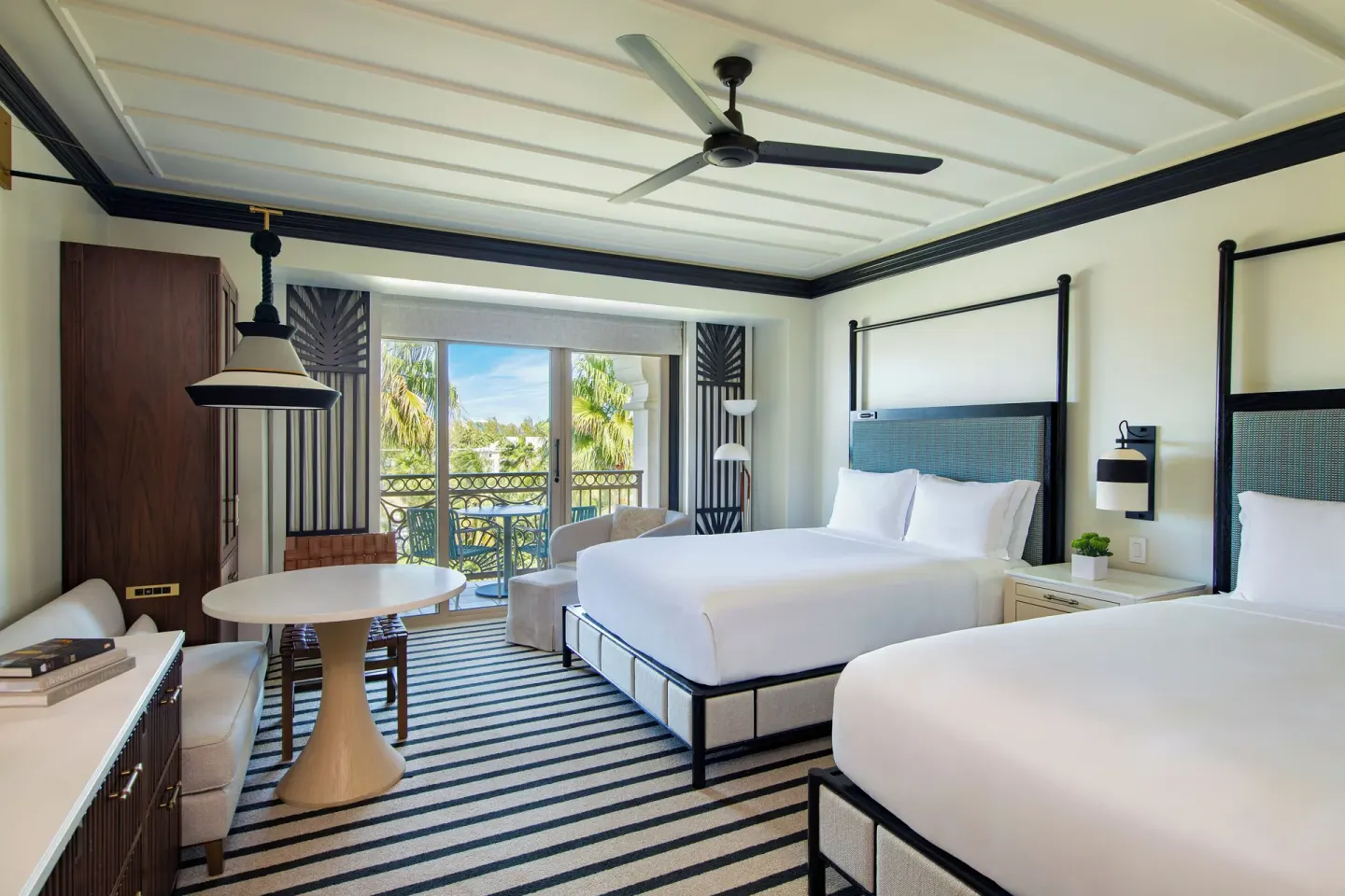 Club Room with two beds, round table, and balcony greenery at The Ritz-Carlton, Grand Cayman.