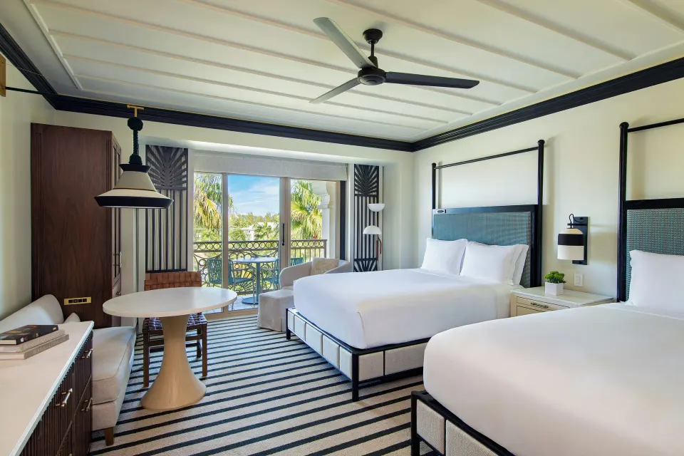 Club Room with two beds, round table, and balcony greenery at The Ritz-Carlton, Grand Cayman.