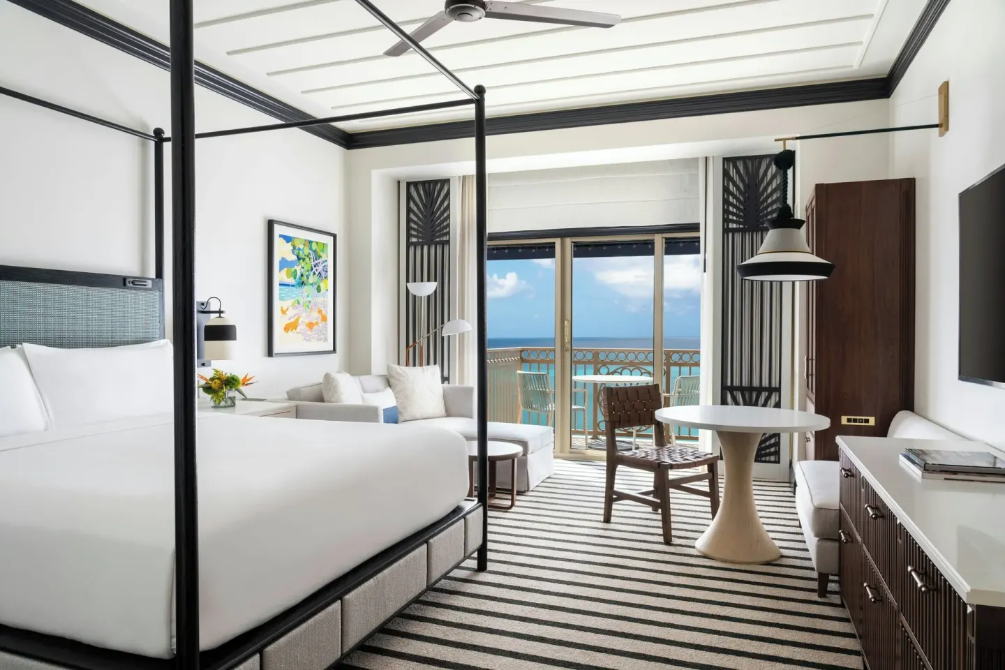 Club Room king bed with seating area and ocean balcony at The Ritz-Carlton, Grand Cayman.