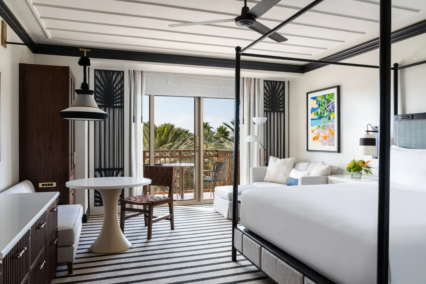 Resort View room with king bed, sofa bed, dining table, and balcony at The Ritz-Carlton, Grand Cayman.