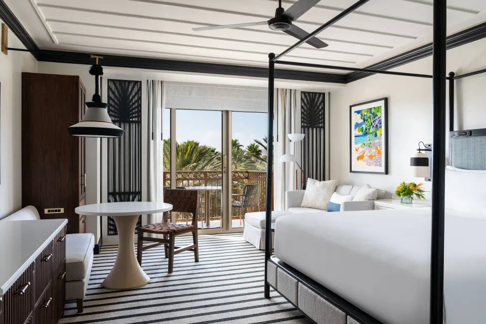 Resort View room with king bed, sofa bed, dining table, and balcony at The Ritz-Carlton, Grand Cayman.