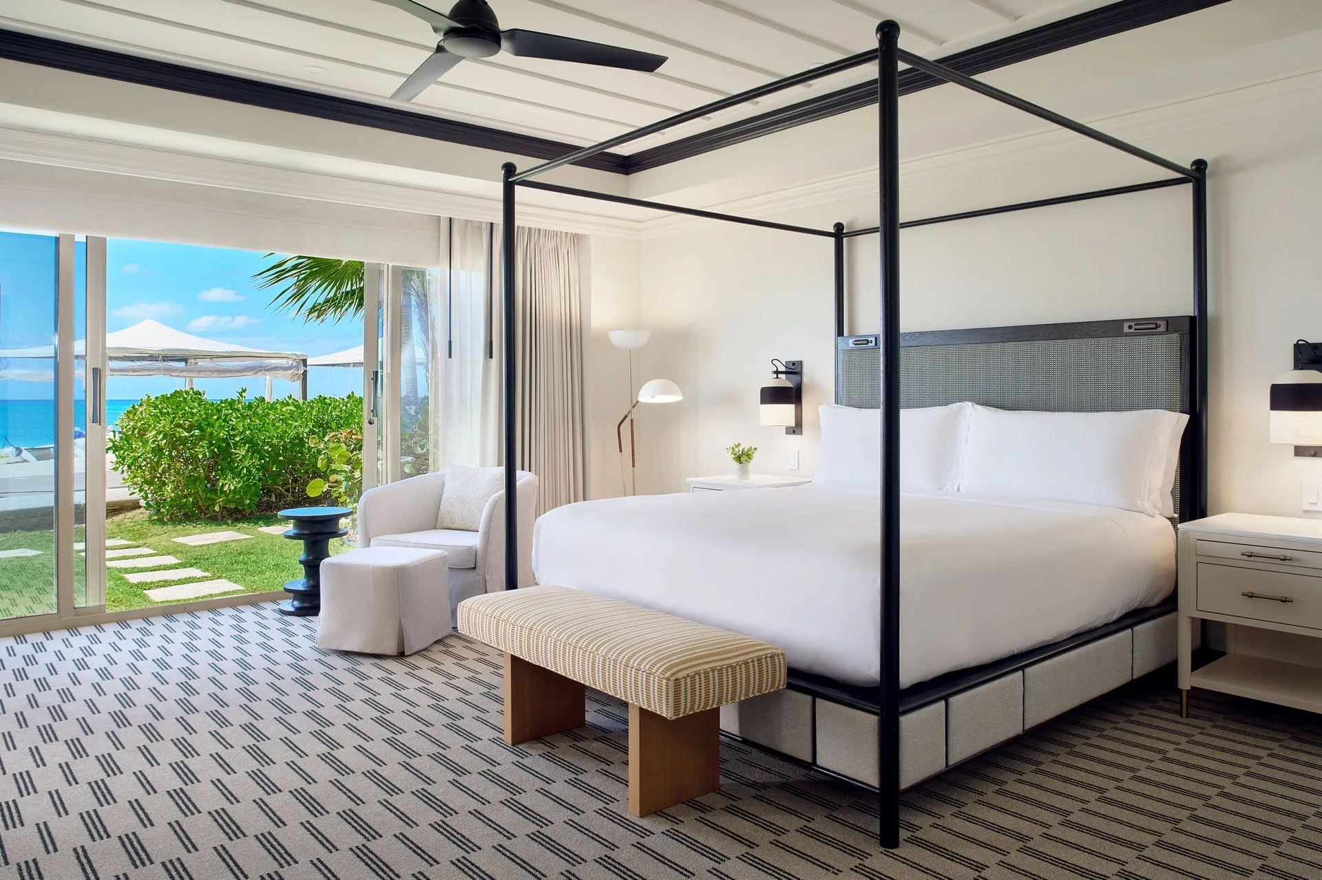 Opal Suite bedroom at The Ritz-Carlton, Grand Cayman with four-poster king bed, oceanfront views, and elegant Caribbean design.