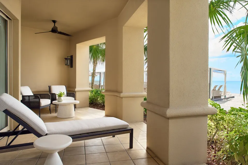 Covered oceanfront patio with lounge seating at The Ritz-Carlton, Grand Cayman.