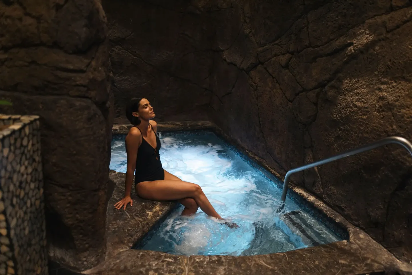 A guest relaxes beside a bubbling spa pool at The Ritz-Carlton Maui, Kapalua.