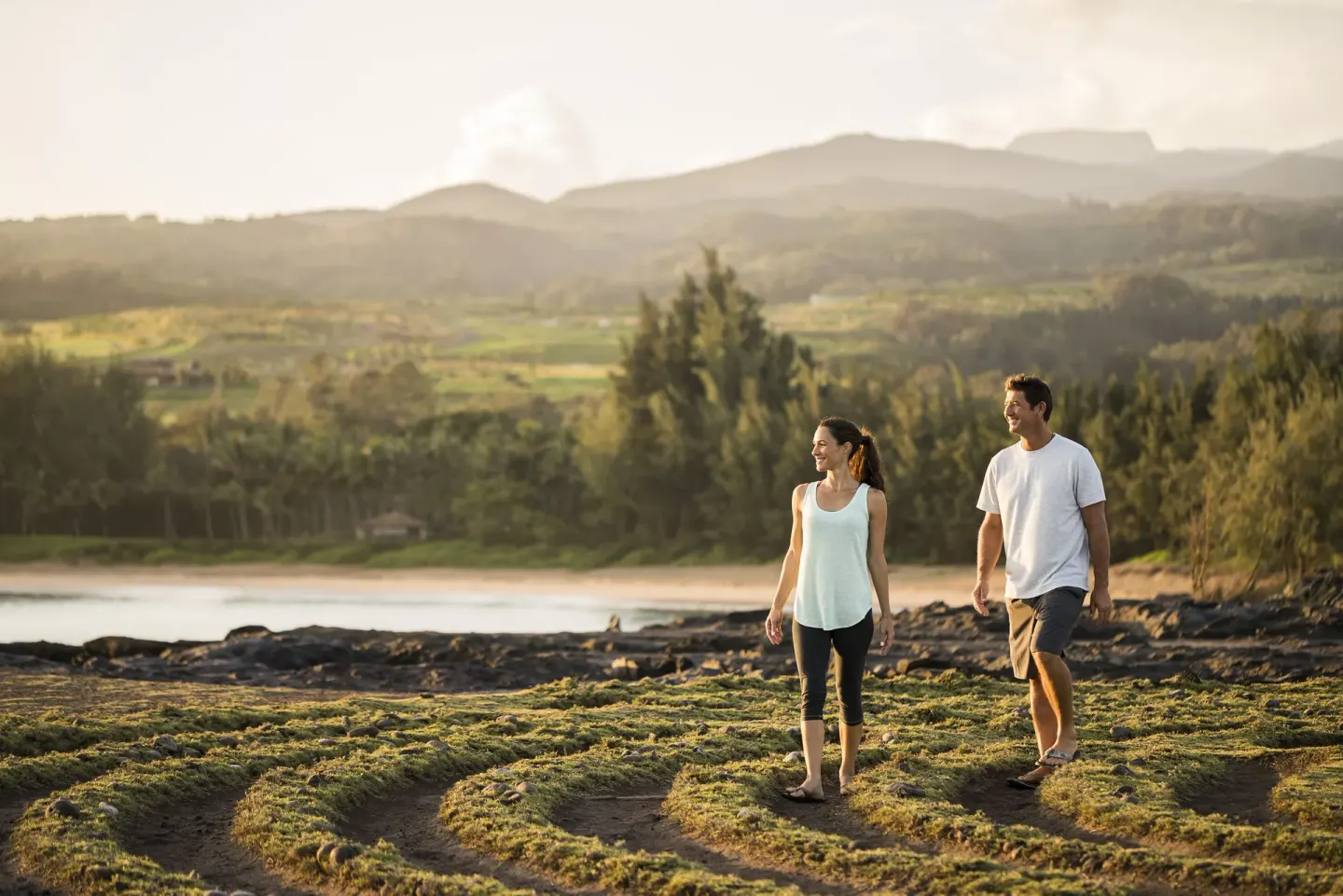 Couple walking along a rocky coastal path near The Ritz-Carlton Maui, Kapalua.
