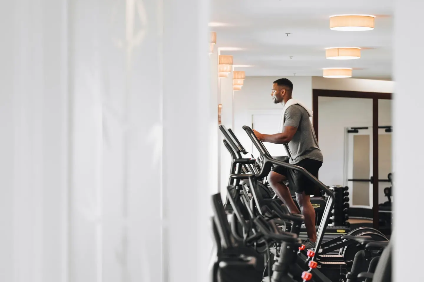Guest using an elliptical machine in the fitness center at The Ritz-Carlton Maui, Kapalua.