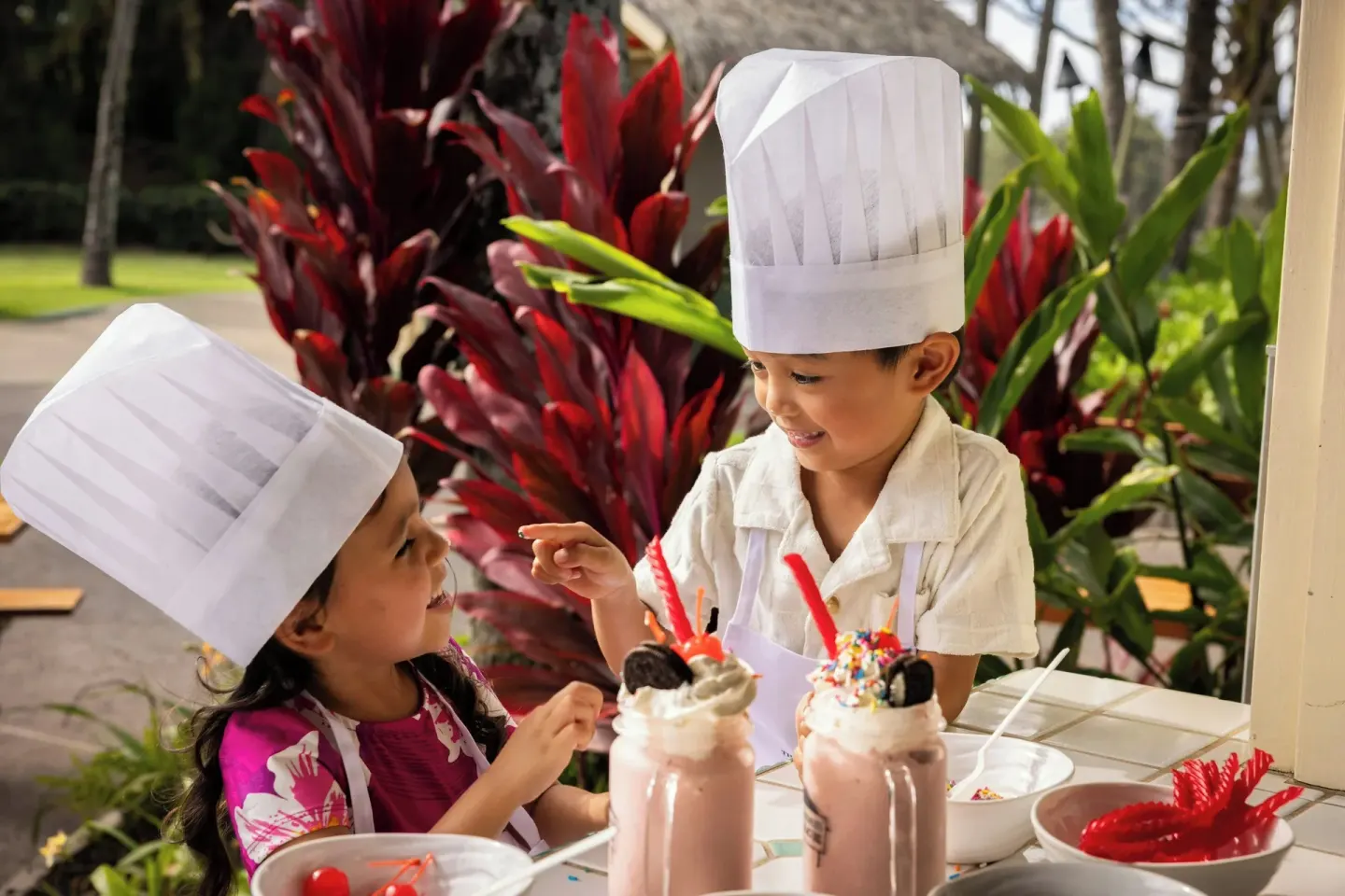 Children in chef hats decorate milkshakes at The Ritz-Carlton Maui, Kapalua.