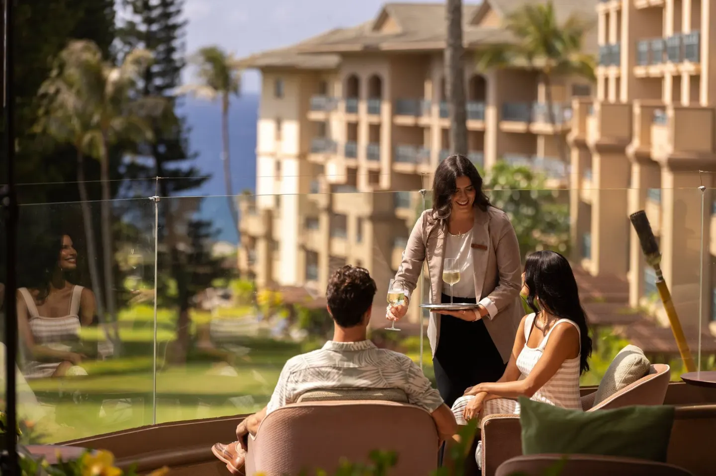Server brings drinks to guests on a terrace at The Ritz-Carlton Maui, Kapalua.