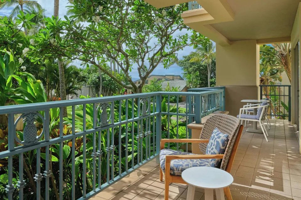 Long furnished balcony with tropical garden views at The Ritz-Carlton Maui, Kapalua.