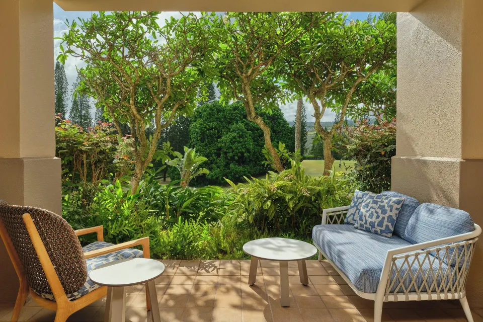 Patio seating framed by tropical garden plants at The Ritz-Carlton Maui, Kapalua.