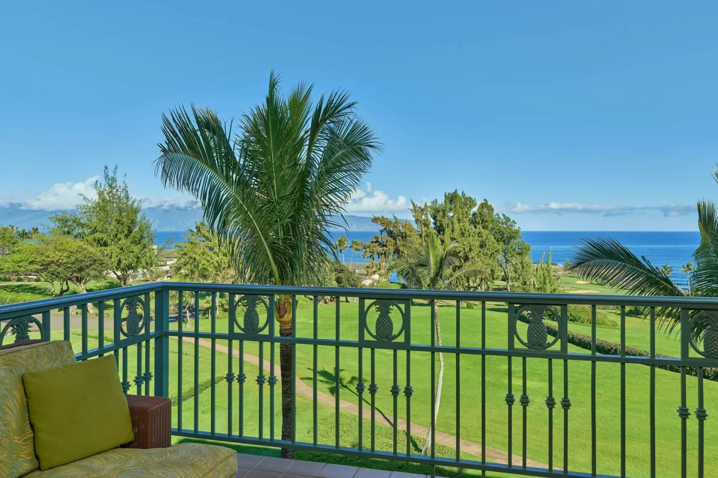 Oceanfront suite balcony view with palms and ocean at The Ritz-Carlton Maui, Kapalua.