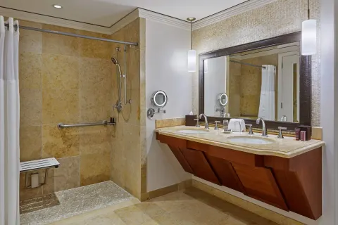 Club Room bathroom with double vanity and roll-in shower at The Ritz-Carlton Maui, Kapalua.