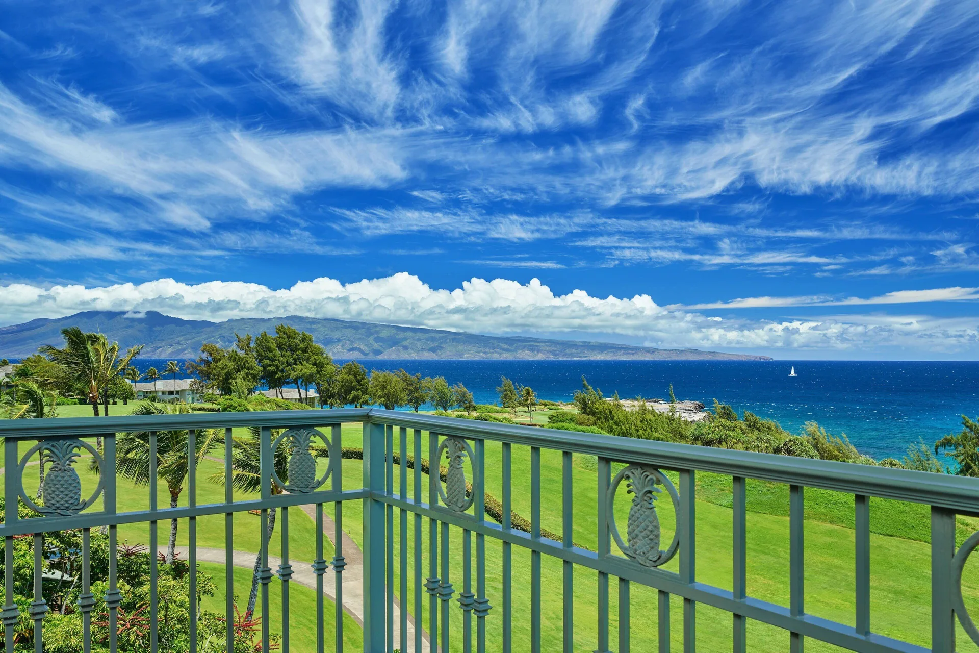 Club Room balcony view of lawn, ocean, and distant island at The Ritz-Carlton Maui, Kapalua.
