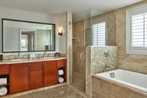 Club Room bathroom with vanity, glass shower, and tub at The Ritz-Carlton Maui, Kapalua.