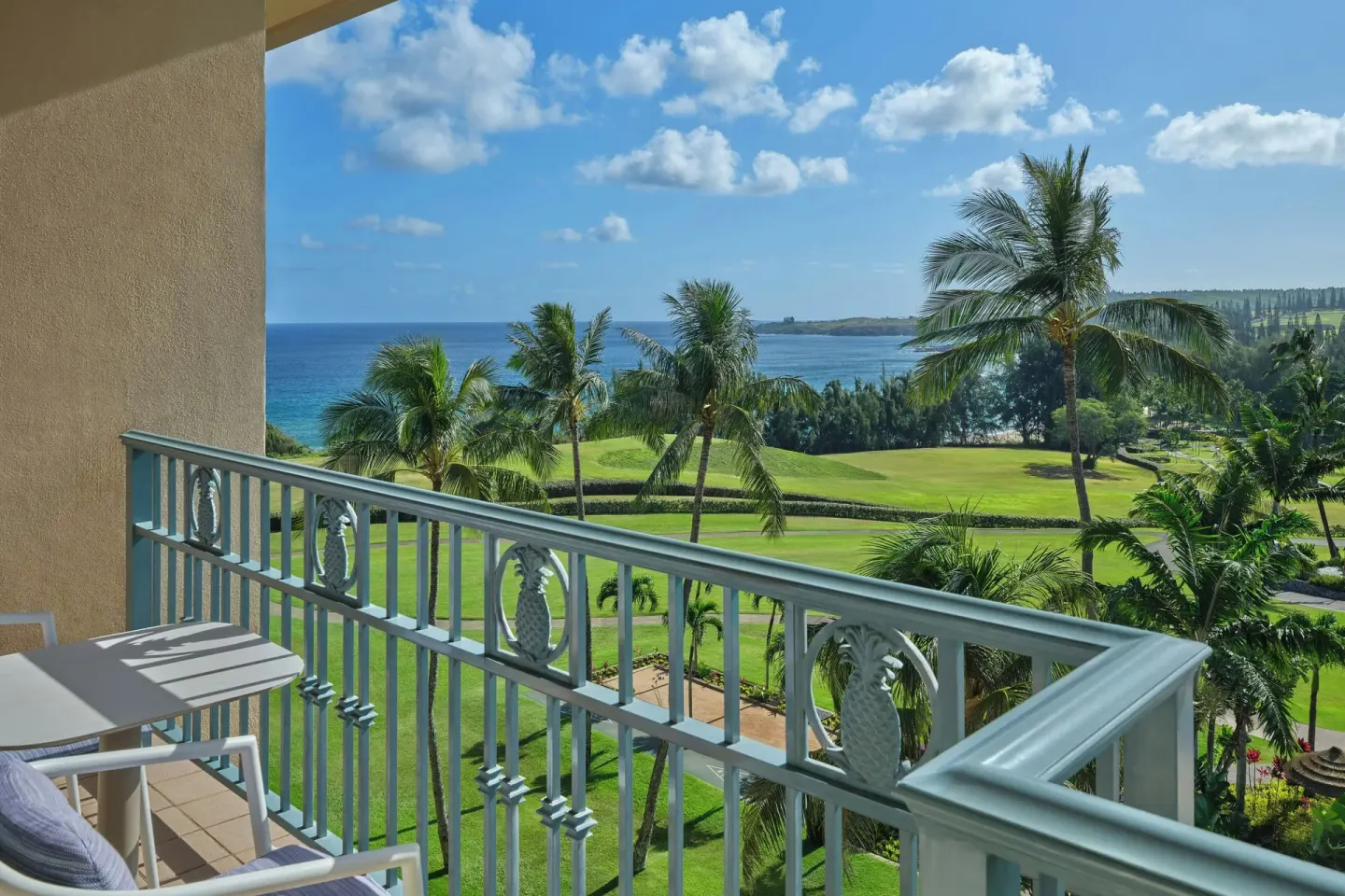 Deluxe Room partial ocean view balcony at The Ritz-Carlton Maui, Kapalua overlooking palms and coastline.