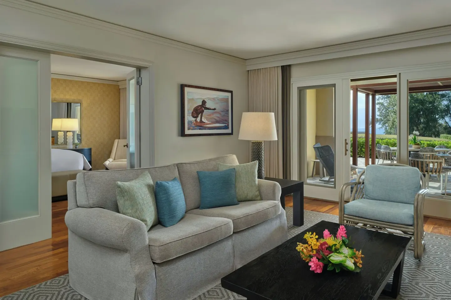 One-bedroom suite living room with sofa and patio doors at The Ritz-Carlton Maui, Kapalua.