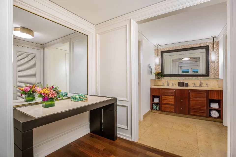 Presidential Suite bath and vanity at The Ritz-Carlton Maui, Kapalua with flowers and double sink counter.