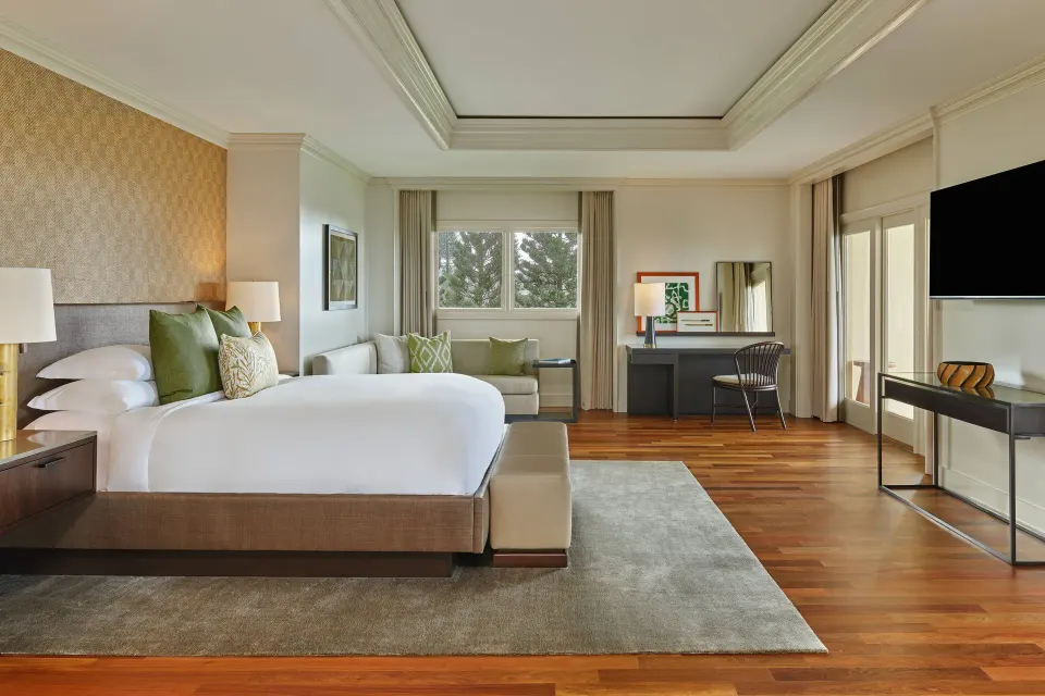 Presidential Suite bedroom at The Ritz-Carlton Maui, Kapalua with king bed, sofa, desk, and TV.