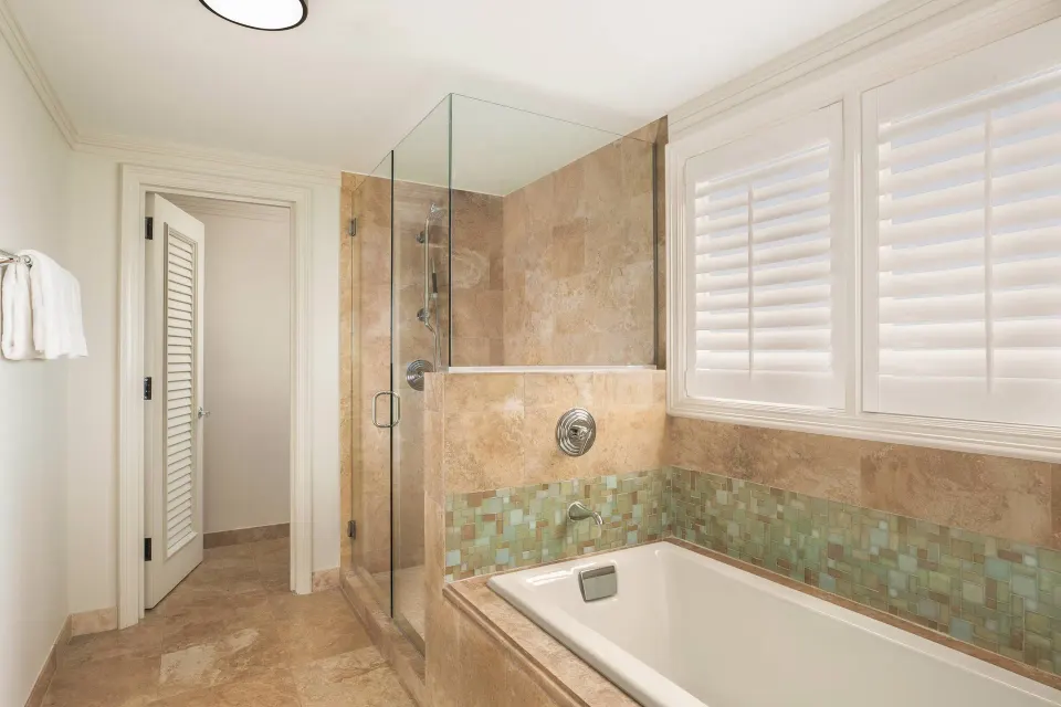 Royal Suite Oceanfront bathroom tub and glass shower at The Ritz-Carlton Maui, Kapalua.