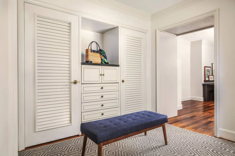 Royal Suite Oceanfront dressing area at The Ritz-Carlton Maui, Kapalua with closets and a blue bench.