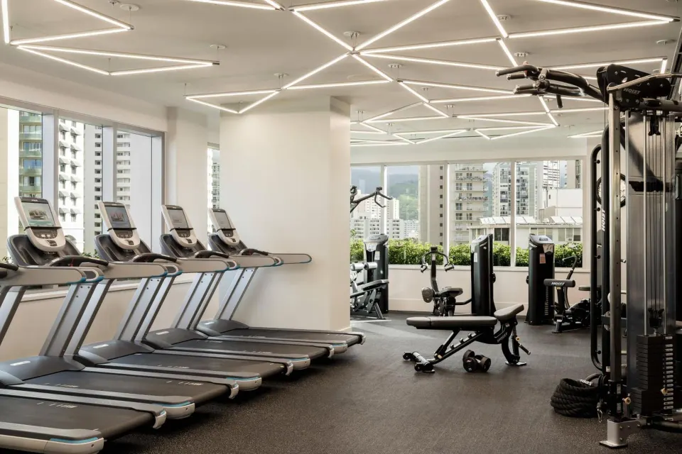 Fitness center with treadmills and weight machines at The Ritz-Carlton Residences, Waikiki Beach.