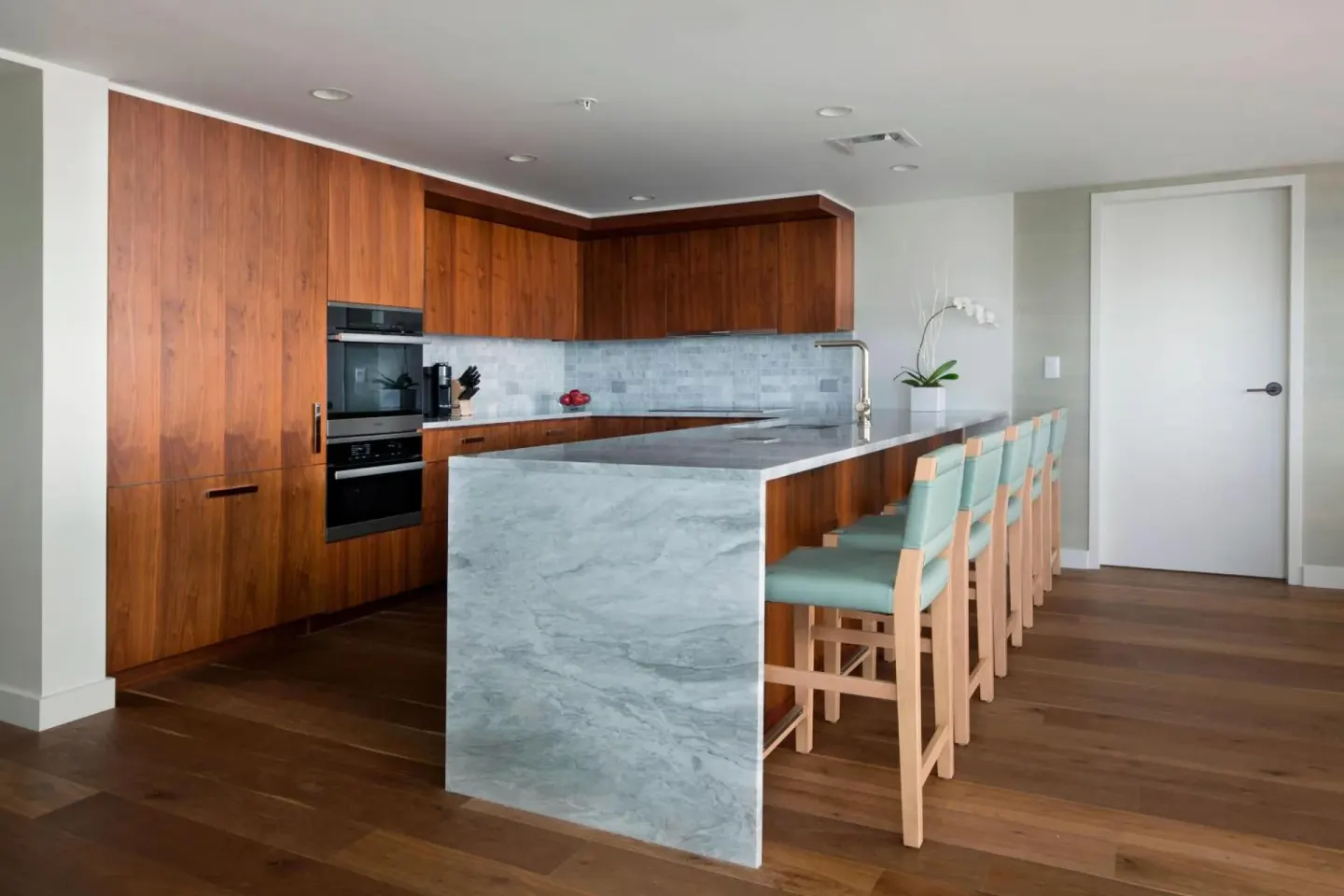 Full kitchen with marble island and bar seating at The Ritz-Carlton Residences, Waikiki Beach.