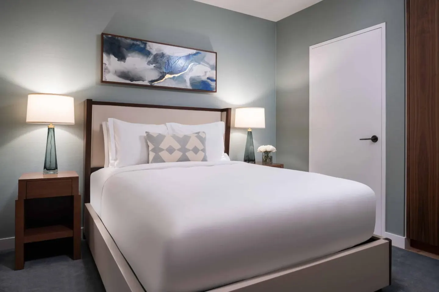Guest bedroom with a king bed and abstract artwork at The Ritz-Carlton Residences, Waikiki Beach.