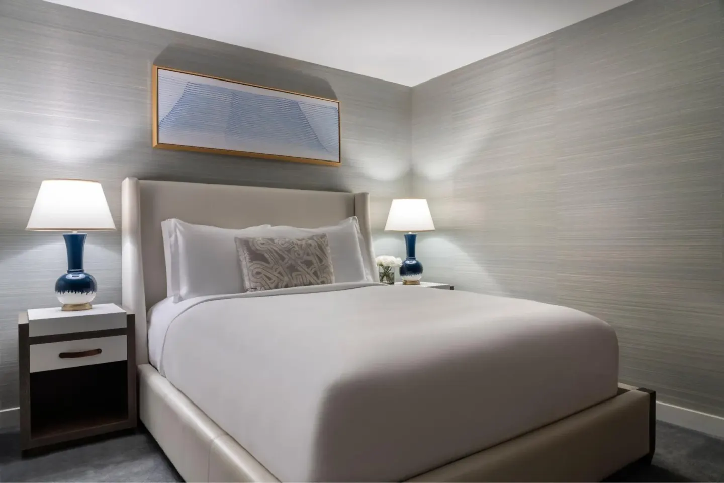 Guest bedroom with a king bed and blue lamps at The Ritz-Carlton Residences, Waikiki Beach.