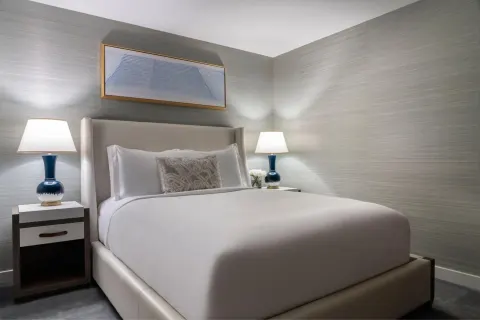 Guest bedroom with a king bed and blue lamps at The Ritz-Carlton Residences, Waikiki Beach.