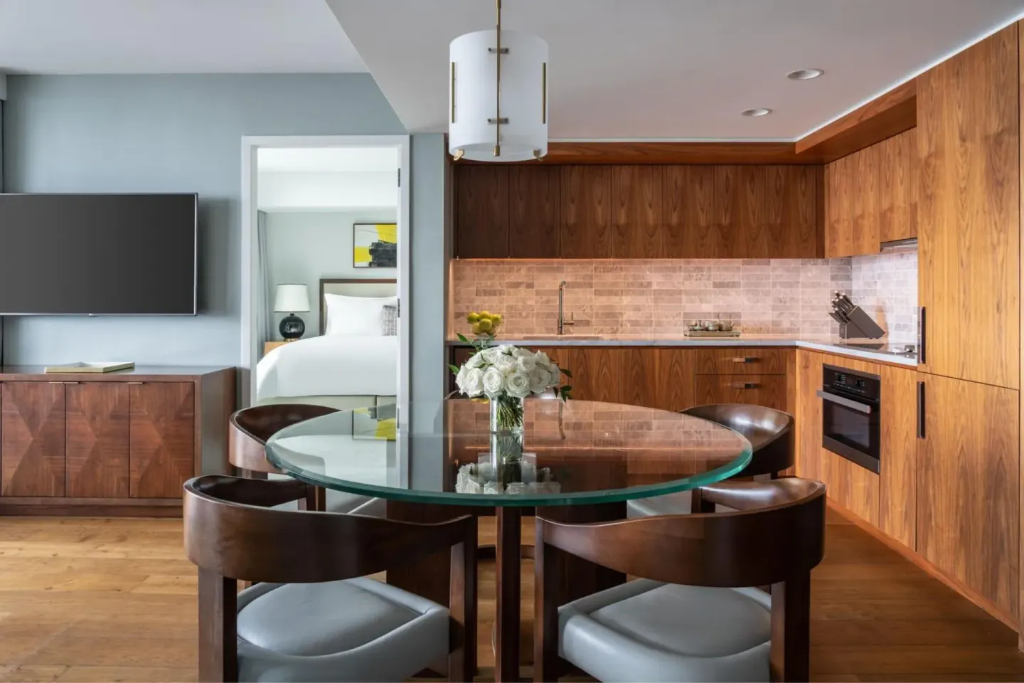 Guest residence kitchen at The Ritz-Carlton Residences, Waikiki Beach with round dining table and bedroom beyond.