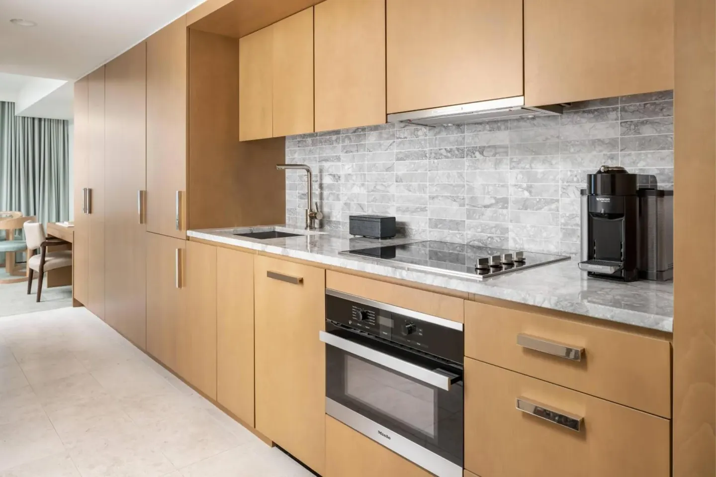 Guest room kitchen with wood cabinetry at The Ritz-Carlton Residences, Waikiki Beach.