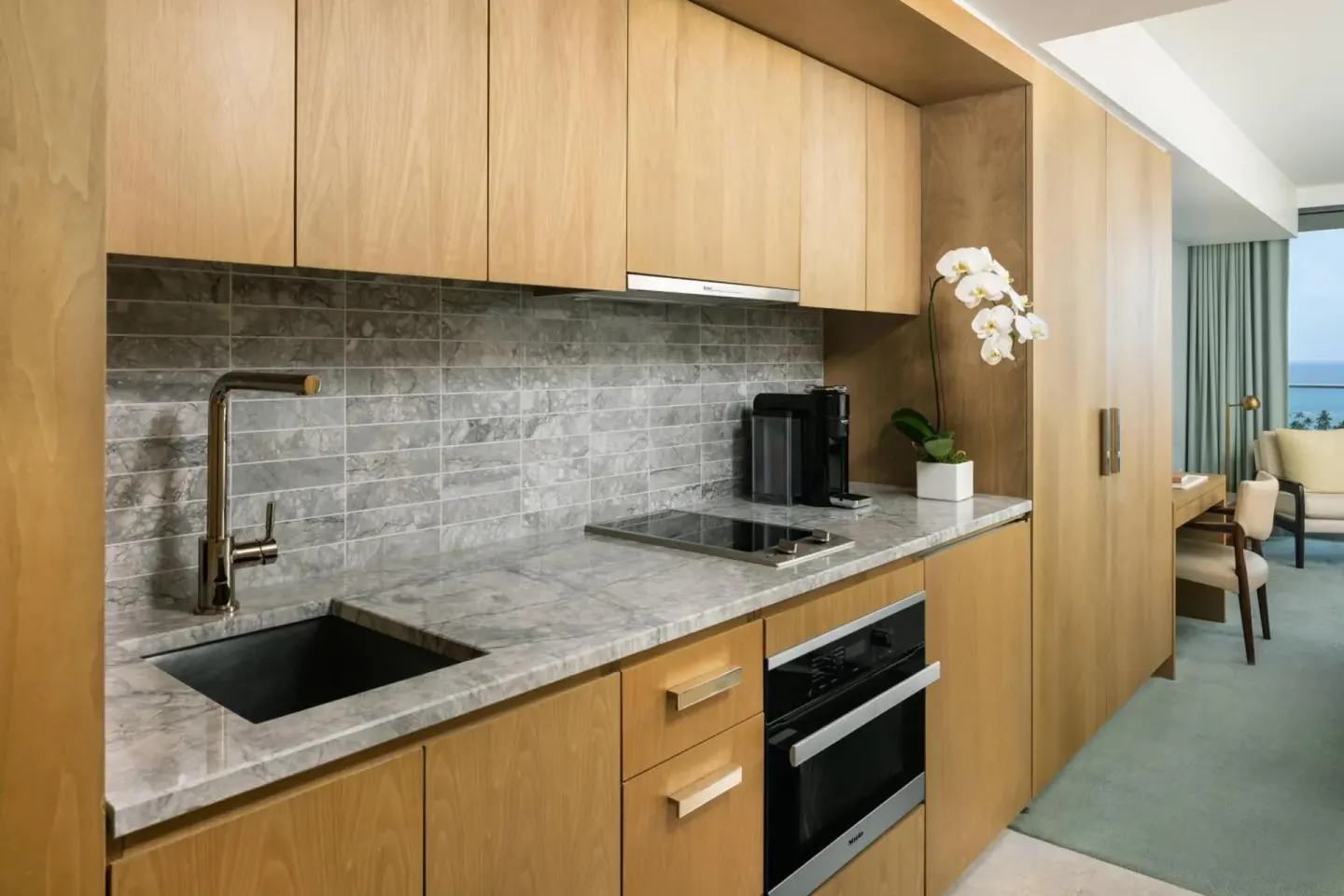 Guest room kitchenette with wood cabinetry at The Ritz-Carlton Residences, Waikiki Beach.
