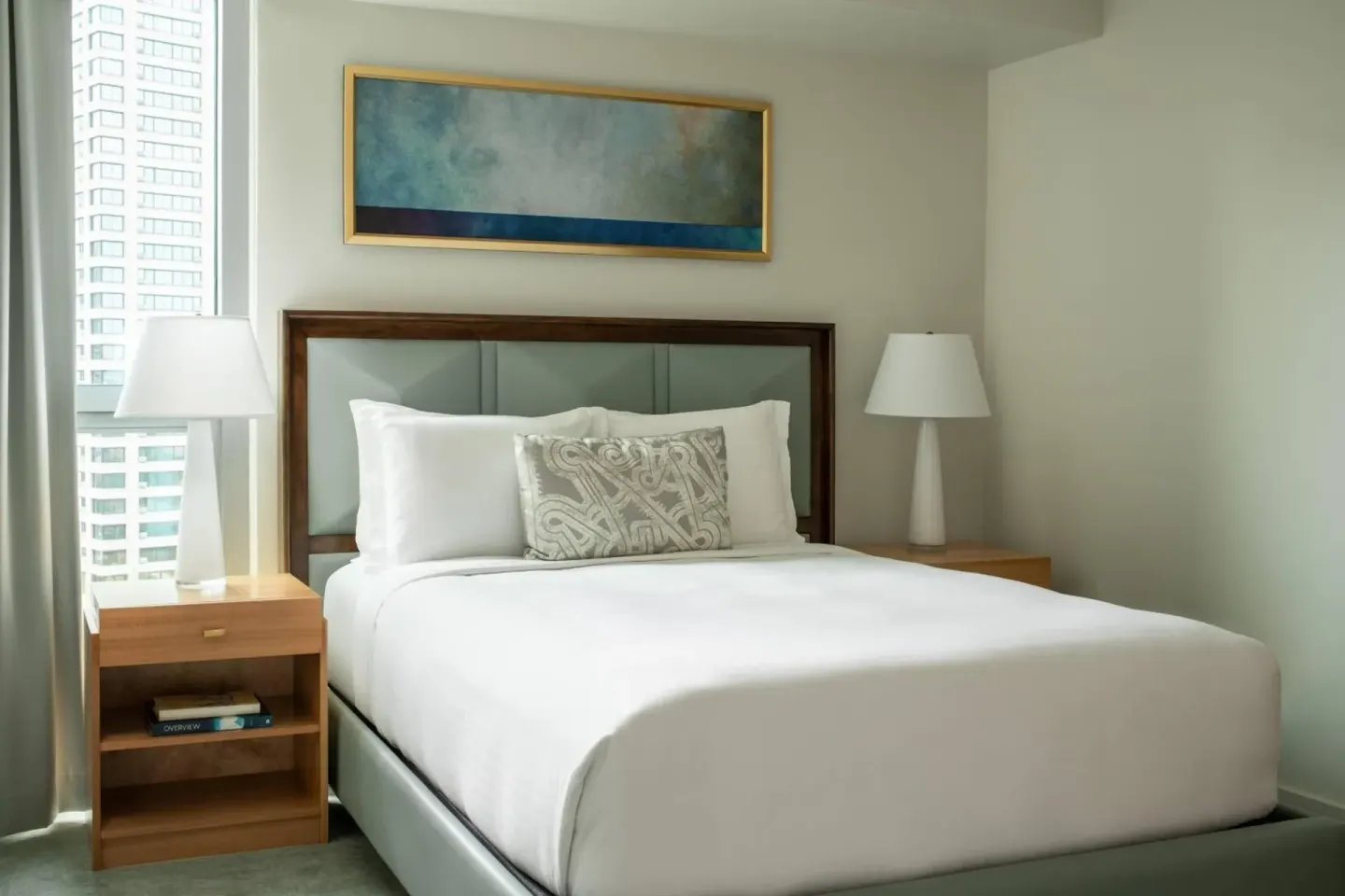 Queen bed guest room with city-facing window at The Ritz-Carlton Residences, Waikiki Beach.