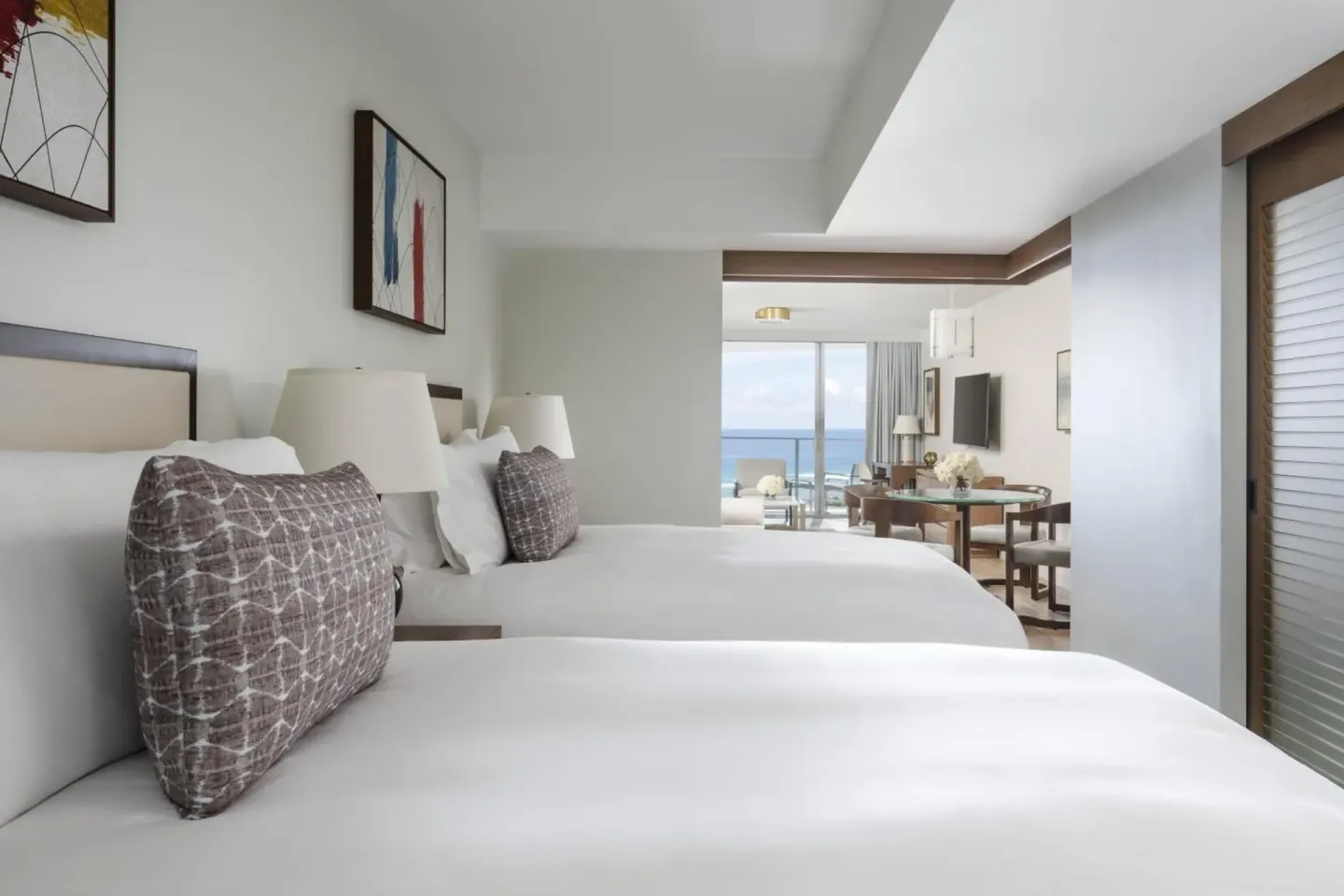 Two-bed guest room at The Ritz-Carlton Residences, Waikiki Beach with ocean view beyond the sitting area.