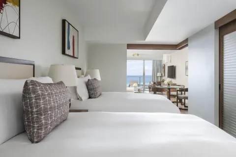 Two-bed guest room at The Ritz-Carlton Residences, Waikiki Beach with ocean view beyond the sitting area.