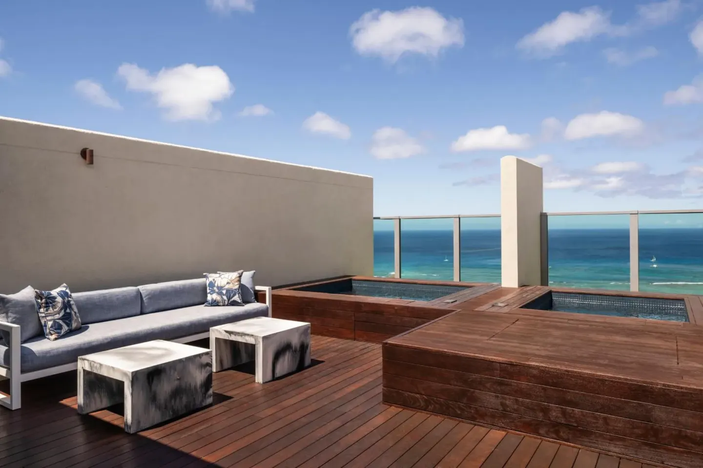 Ocean-view terrace with sofas and plunge pools at The Ritz-Carlton Residences, Waikiki Beach.