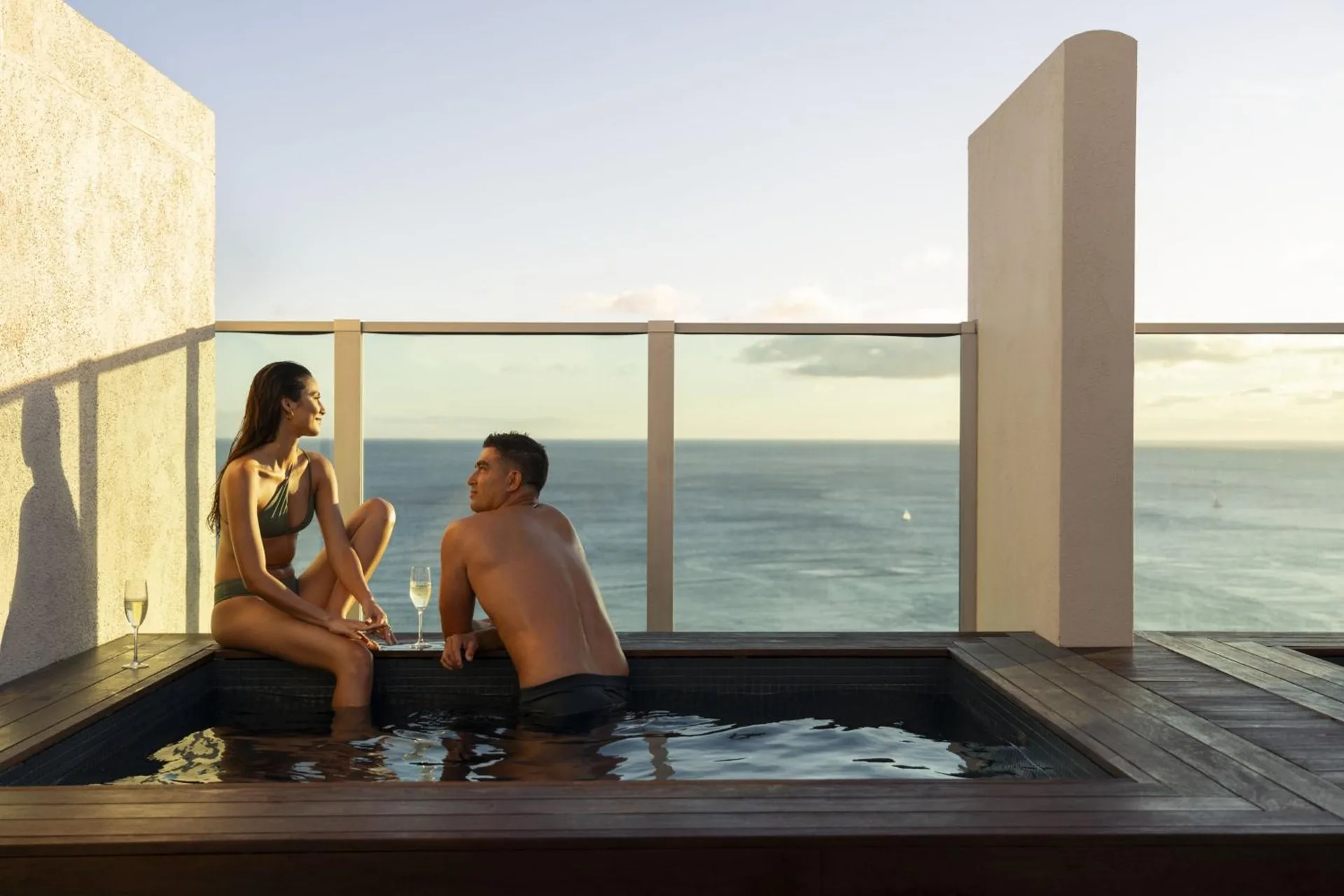 Couple in a plunge pool facing the ocean at The Ritz-Carlton Residences, Waikiki Beach.