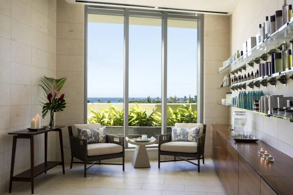 Spa lounge at The Ritz-Carlton Residences, Waikiki Beach with chairs, candles, and ocean view.