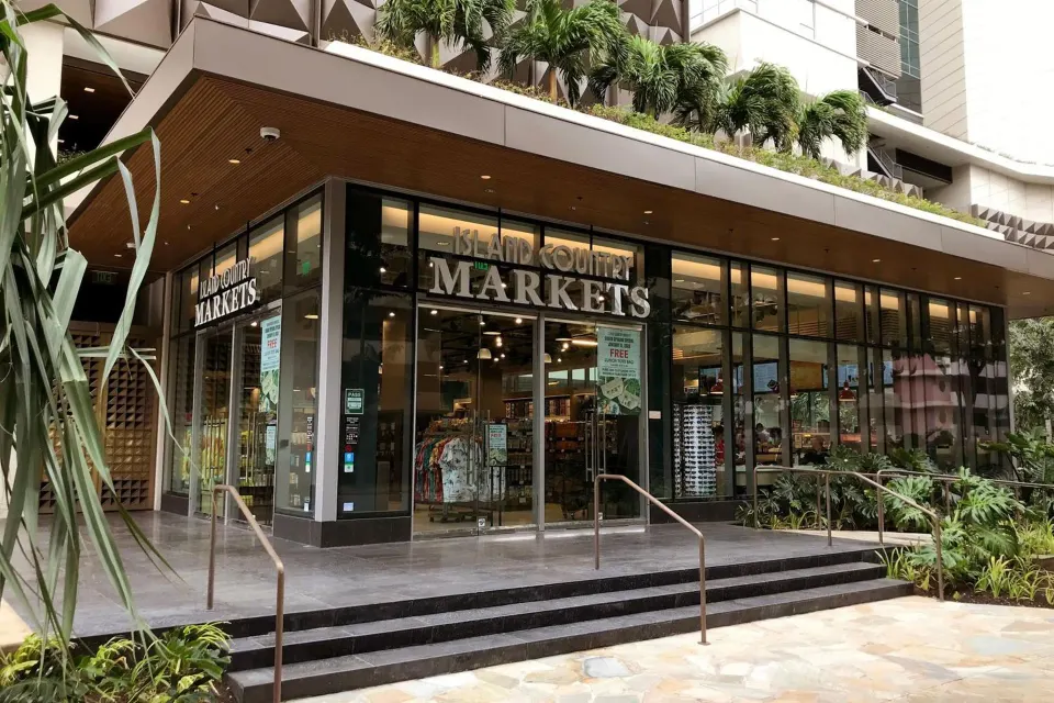 Street-level market entrance at The Ritz-Carlton Residences, Waikiki Beach with glass storefront.