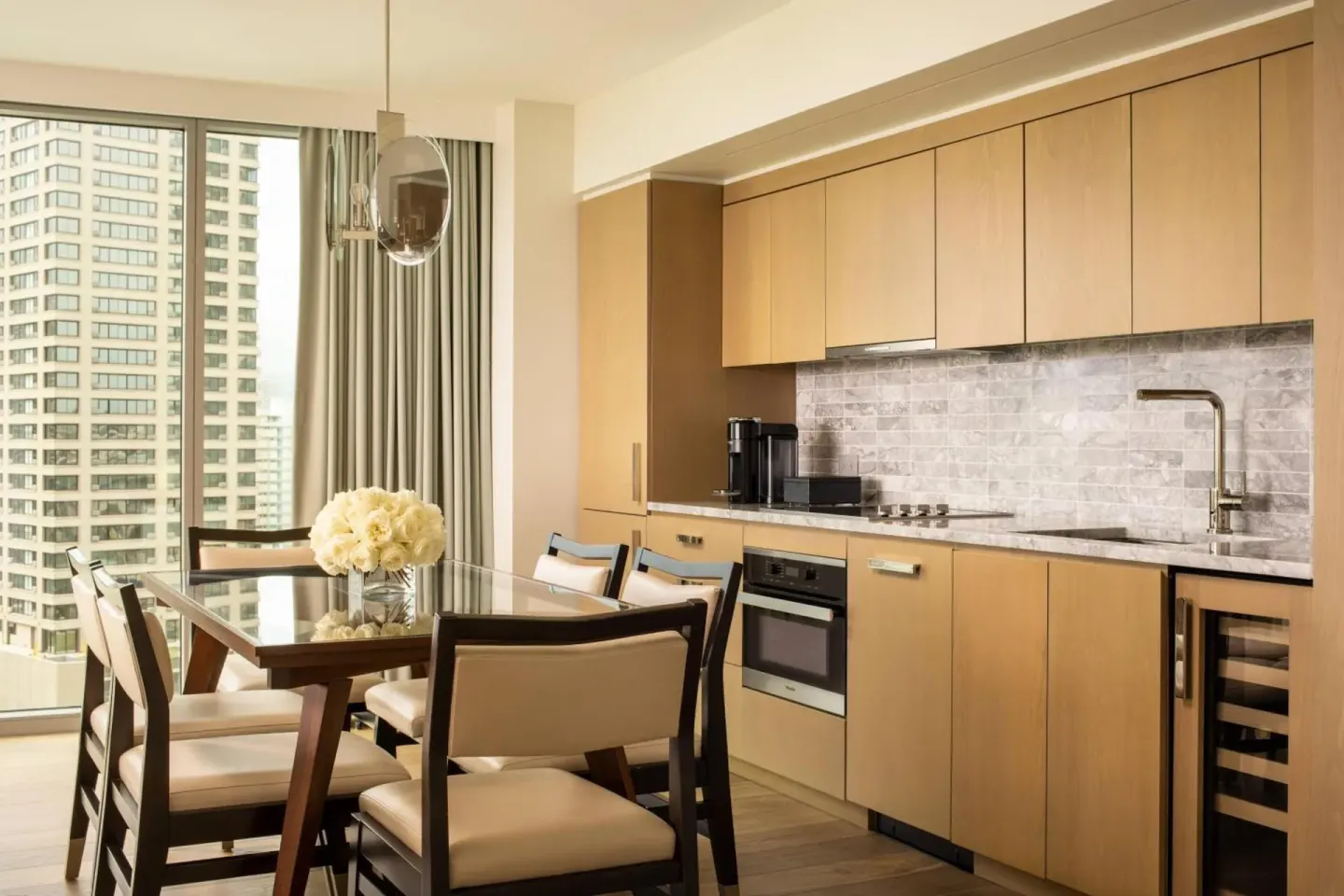Suite dining area and kitchen with city view at The Ritz-Carlton Residences, Waikiki Beach.